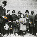 Rev Wong with children in Collingwood, holding oranges. Photographer: T. W. Cameron