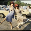 Two unidentified women kicking up their heels in carpark at racecourse © Rennie Ellis